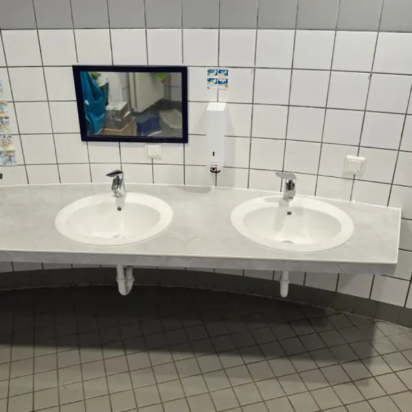 Waschtisch mit zwei Becken in einem gefliesten Waschraum