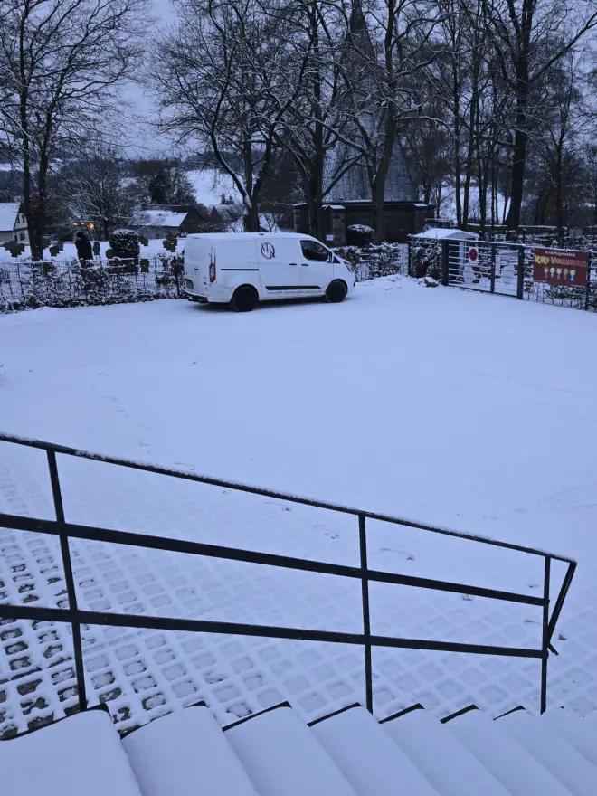 Vorher: Treppe, Geländer und Parkplatz unter einer geschlossenen Schneedecke